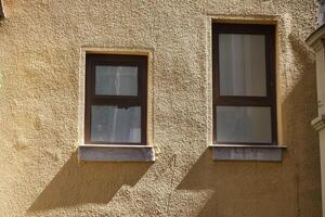 Charming Urban Windows Designed with Shadows Projecting on a Textured Wall Background photo