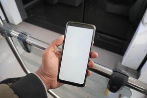 young man hand using smart phone with green screen inside of metro train photo