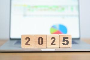 Happy New Year 2025 block with computer laptop background. Goal, Target, Resolution, strategy, plan, Action, mission, motivation, and New Year start concepts photo