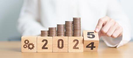 2024 end year to Happy New Year 2025 with Coins stack and gear icon. business Process, Team, teamwork, Strategy, goal, Money, Budget, investment, financial and New Year Resolution concept photo