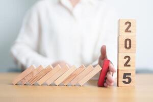 2025 year with falling blocks on table, Risk Management, recession, business financial, Resolution, strategy, goal, New Year planning and inflation deflation and economic recession concepts photo