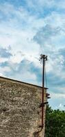 Old street concrete pillar with rusty iron part at top and cut wires. Installation or dismantling of electricity. Broken energy pole. photo