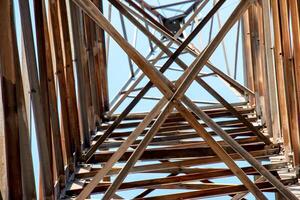 Close-up view of an electric tower with a beautiful blue sky background. Industrial engineering concept. Iron structure for high-voltage electrical engineering. photo