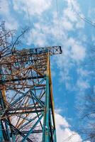Close-up view of an electric tower with a beautiful blue sky background. Industrial engineering concept. Iron structure for high-voltage electrical engineering. photo