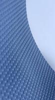 Curved Edge Of Sheet Of Elastic Material With 3D Extruded Circles On It. Stock Photo For Abstract Blue Backgrounds