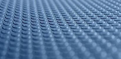 Round embossed pattern on a blue porous material with defocused top and bottom edges. 3d background stock photo
