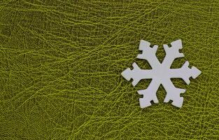 Artificial Snowflake Isolated On Green Patterned Surface With Empty Space At A Side Of Image. Winter Background Design. White 3D Printed Snowflake On Green photo