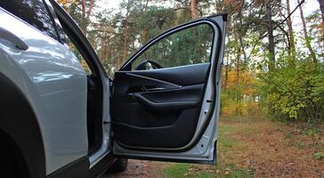 Bottom View Of White SUV With Opened Front Door At Forest With Autumn Leaves. Vehicle Journey To Forest photo