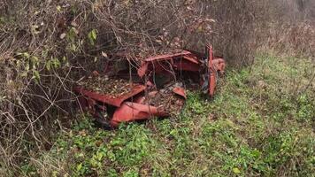A rusty, vintage tractor lies long neglected in an overgrown field, seamlessly blending with the surrounding nature video