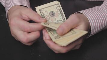 A closeup image of hands carefully counting cash, which underscores the significance of effective money management video