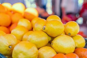 Fresh lemons are stacked on supermarket shelf and ready for purchase. Each lemon is ripe and full of citrus notes. Ideal for demonstrating availability and quality of fresh lemons in grocery stores. photo