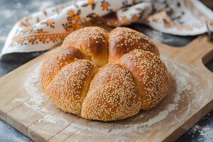 Sesame bread on wooden board, floury surface and patterned cloth evoke warmth photo