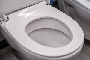 Closeup of an empty toilet in a bathroom with ceramic seat and rectangle shape photo