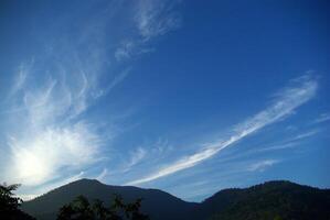 Clouds drifting over forests and mountains photo