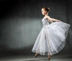 Ballet. Image of a flexible cute ballerina dancing in the studio. Beautiful young dancer. A ballerina is posing. photo