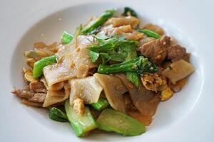 Close up Stir fry pork noodles with black soy sauce photo