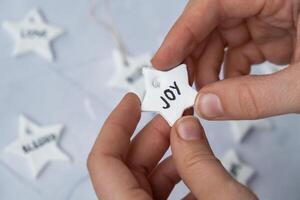 Christmas star with word JOY Creator is using white air dry clay for making decor to Christmas tree holiday. Creating hobby recreation activity that involves fingers. DIY crafting Modern art photo