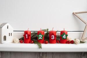 Traditional four advent weeks before Christmas holidays. Red candles with numbers and plastic free decoration. Copy space greeting card mock up template. Winter cozy home time photo