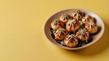 Takoyaki, Japanese dumplings on a plate on yellow background photo