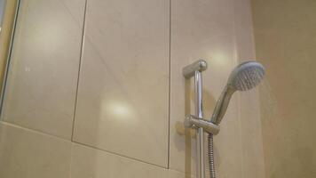 Shower head with wall background in modern bathroom. Shower with water flowing from it in a hotel room. View of a shower with water flowing from it. photo