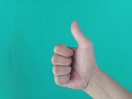 Thumbs up gesture, horizontal view, green background photo