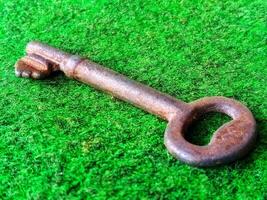 Ancient key on green carpet with close up horizontal view photo