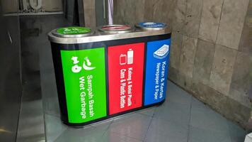 a trash can with three categories of trash. wet, plastic and paper waste photo