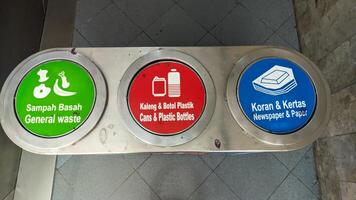 a trash can with three categories of trash. wet, plastic and paper waste photo