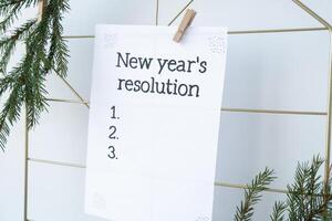 Vision board with NEW YEAR'S RESOLUTION aims goals on paper note. Preparation for New Year. Concept of planning and setting goals for personal development photo