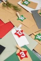 Number on craft envelopes notes with tasks before Christmas holidays. Female making kraft paper for handmade advent calendar Made with your own hands step by step DIY crafts do it yourself photo
