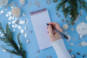 Woman writing letter to SANTA or promises and aims. Empty notebook Preparation for new year. Visualizing wish list for 2025. Dreams plan action resolutions for coming year. Inspirational self improvement concept photo