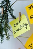 EAT HEALTHY goal on Vision board with new year resolutions aims on sticky notes. Preparation for New Year. Concept of planning and setting goals for personal development photo