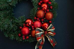 Handmade Christmas wreath from festive red decorations. Festive holiday preparation craft master class of creative making decor. Hands-on activities sustainable responsible holiday gift workshop creation. Top view, flat lay photo