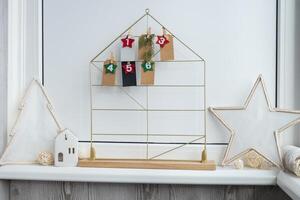 Number on craft paper notes with tasks before Christmas holidays. Female making kraft paper for handmade advent calendar Made with your own hands step by step DIY crafts do it yourself photo