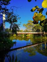 Pedestrian footbridge with reflection in still water on a bright sunny day, Nimman, Chiang Mai, Thailand, 2024 photo