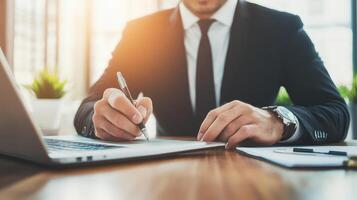 A focused businessman takes notes at his home office desk, capturing essential details for effective planning and strategy. photo
