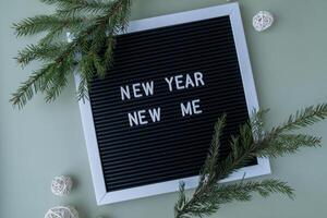 Letter board with inspirational message NEW YEAR NEW ME with fir branches on pastel background. Happy new year promises resolutions concept. Self growth and personal development photo