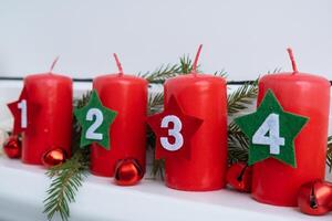 Traditional four advent weeks before Christmas holidays. Red candles with numbers and plastic free decoration. Copy space greeting card mock up template. Winter cozy home time photo