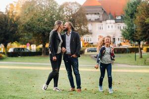 A happy family of three runs through the grass in Austria's old town.A family walks through a small town in Austria.Europe.Velden am werten Zee photo
