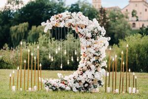 Wedding ceremony on b street near the Nesvizh castle.Decor with fresh flowers in the form of the moon. photo