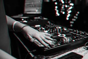hand of a DJ girl on the background of a music controller mixer photo