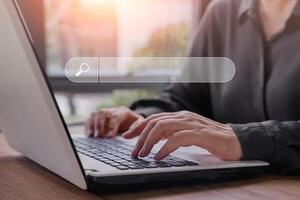 Hand of businessman searching, browsing internet data information with blank search bar. Search Engine Optimization SEO Networking Concept.Businesswoman working with computer laptop on desk in office. photo
