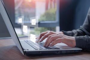 Email marketing. Businessman hands using Laptop typing on keyboard and surfing the internet on office table with email icon, send mails or news letter, company digital online working internet network. photo