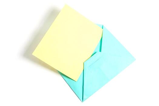 Top view of open blue envelope with yellow paper sheet isolated on white background. photo