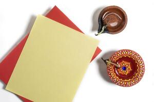 Happy Diwali celebration greeting card and clay diya lamp on white background. photo