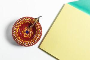 Happy Diwali celebration greeting card and clay diya lamp on white background. photo