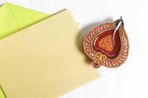 Diwali greeting card with festive diya lamp on white background. photo