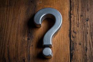 Question mark is on a wooden surface with a metal object in the middle photo