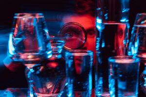psychedelic surreal portrait of a man through a magnifying glass and glasses of water with blur photo