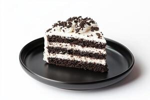 A single slice of chocolate cake with white frosting and chocolate sprinkles on a black plate against a white background. photo